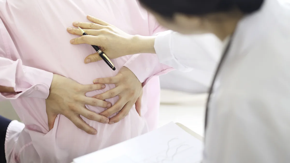 의료진이 환자의 복부를 손으로 진찰하는 모습