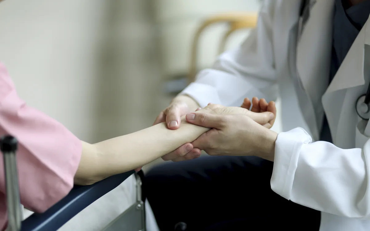 의료진이 환자의 손목 관절을 두 손으로 잡고 진찰하는 모습