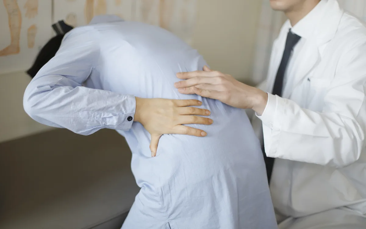 대상포진 초기증상으로 한쪽 허리와 옆구리 통증을 호소하는 환자를 진료하는 의사